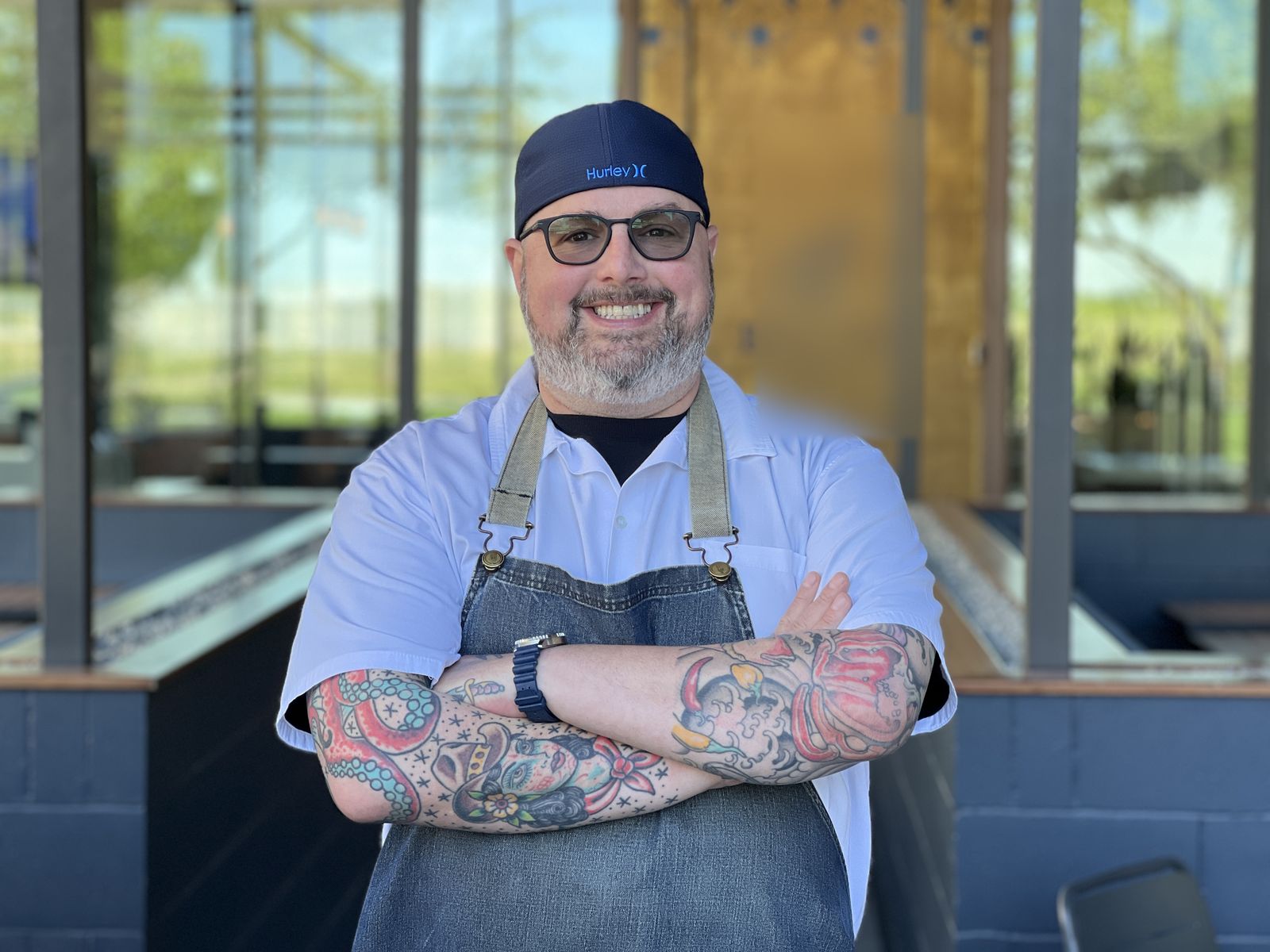 Chef Justin Turner in a chef’s coat and apron, arms crossed